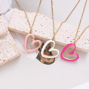 Detailed view of pink, white and rose irregular enamel heart pendants on gold chains