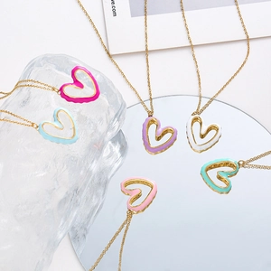 Detail of colorful irregular hollow heart pendants on gold chains over crystals