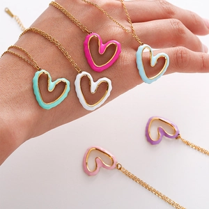 Detailed macro of irregular hollow heart pendants with colorful enamel in gold settings