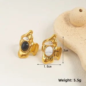 Detailed view of irregular metal stud earrings with size measurements in natural light