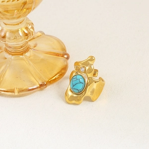 Macro shot of irregular gold stainless steel ring with blue stone and tiny crystal detail