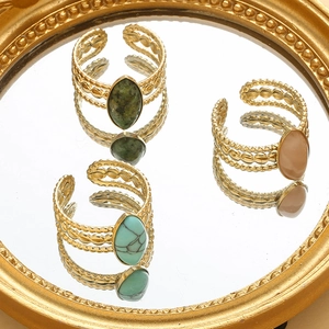 Macro view of vintage gold hollow rings with green turquoise and marble stones