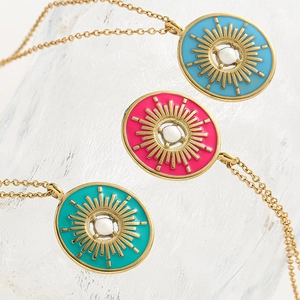 Détail des pendentifs émaillés soleil avec perles sur colliers en or élégants