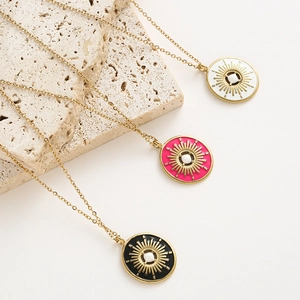 Vue détaillée de colliers dorés vintage avec pendentifs soleil émaillés en trois couleurs