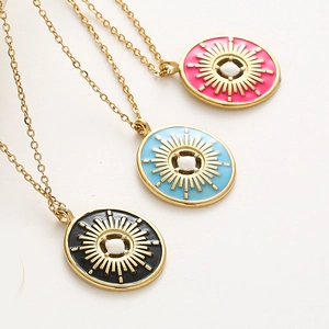 Détail de trois colliers en émail soleil en rose, bleu et noir avec perles blanches