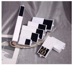 Minimalist white pull-out jewelry boxes for rings and necklaces on a vintage tray
