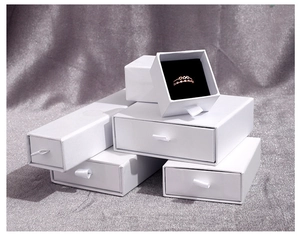 Minimalist white slide-out jewelry boxes with soft black velvet lining and pull ribbon