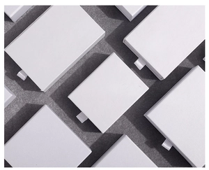 Multiple minimalist white drawer-style jewelry boxes with pull tabs on a grey surface