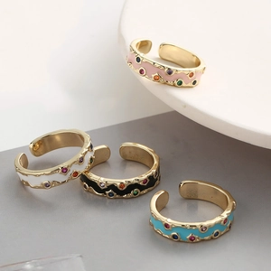 Détail de bagues émaillées colorées plaquées or avec des accents de zircon brillant