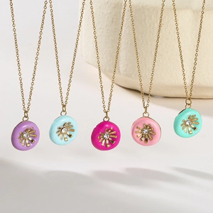 Detail view of five colorful sunflower coin pendants with gold chain and crystals
