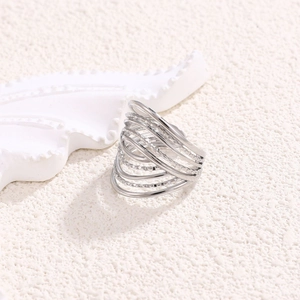 Macro detail of silver multi-layer intertwined ring with textured beaded lines