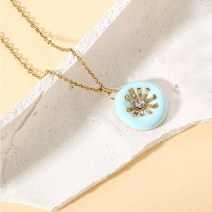 Detail of gold necklace featuring light blue enamel sunflower pendant with a bright zircon center