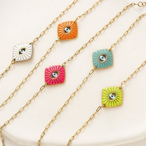 Detailed view of colorful evil eye enamel charms on golden paperclip chains