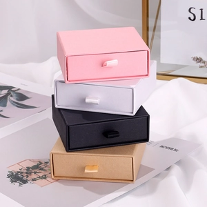 Elegant drawer jewelry boxes in pink, white, black, and kraft paper with ribbon pull handles
