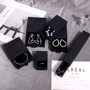 Various sizes of black drawer jewelry boxes showing assorted necklace and earring sets