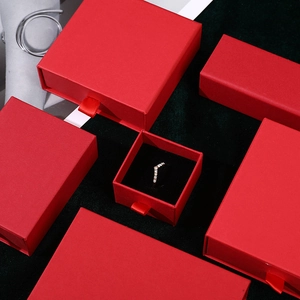 Macro view of red matte drawer jewelry boxes for rings and necklaces on green velvet