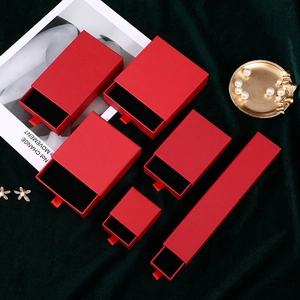 Set of luxury red drawer jewelry boxes in various sizes on deep green velvet background