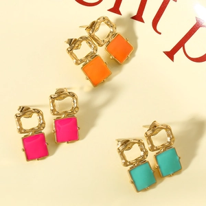 Macro shot of geometric square earrings with colorful hammer texture and golden base