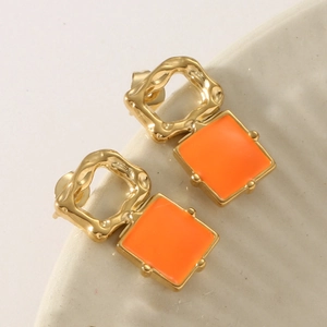 Detail view of vintage geometric square earrings with gold texture and orange enamel inlay