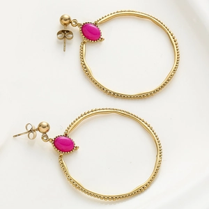 Detalle de pendientes de aro dorados con piedras rojo rosa y patrón de ondas texturizadas