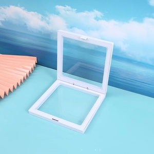 Detailed view of white PE film floating jewelry box opened at 90 degrees on a blue desk