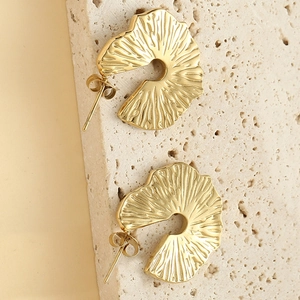 Bohemian irregular ruffled 14K gold-plated stud earrings on a textured stone surface