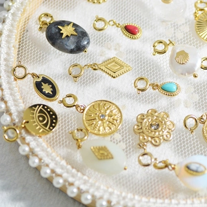 Macro detail of vintage gold plated steel charms with natural stone and evil eye designs