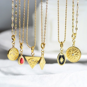 Macro detail of vintage gold plated evil eye and natural stone charms on necklaces