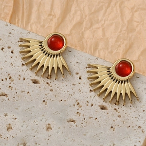 Vintage gold fan-shaped stud earrings with red stone inlay on natural stone background
