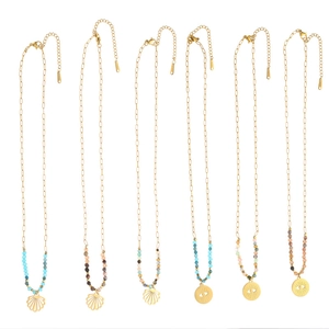 Detail of bohemian gold necklaces with shell pendants, evil eye charms and colorful beads