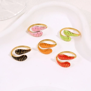 Colorful enamel stripe snake rings in gold plating arranged on a white ceramic tray