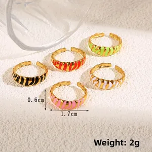 Detail of 0.6cm wide golden open rings with colorful zebra print enamel and sizing info