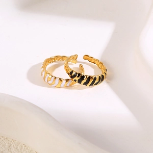 Detail of vintage enamel rings featuring black and white zebra patterns on gold-plated bands