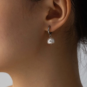 Elegant baroque freshwater pearl earrings with stainless steel hoops on a model