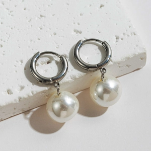 Detailed view of baroque freshwater pearls on silver stainless steel hoops on stone