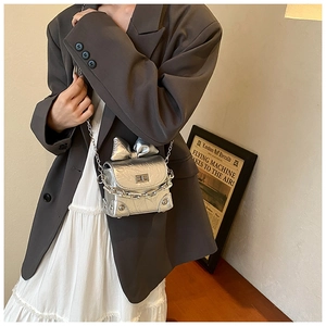 Detail of silver mini box bag with metallic bow, chain strap and textured leather finish