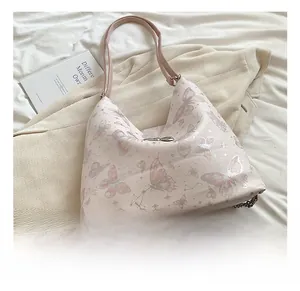 Detail of pink butterfly print tote bag with metallic chain and leather shoulder strap