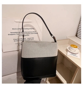 Detail of canvas and black leather bucket bag next to a coffee cup in a city setting