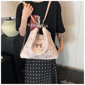Detail of pink butterfly print tote bag with golden bow clasp and chain strap