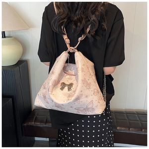 Detail of pink butterfly tote with metallic bow clasp and stylish silver chain straps