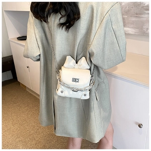 Detail of mini bow crossbody bag in cream patent leather with silver chain strap