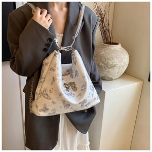 Detail of butterfly print tote with metallic bow accent and stylish chain strap