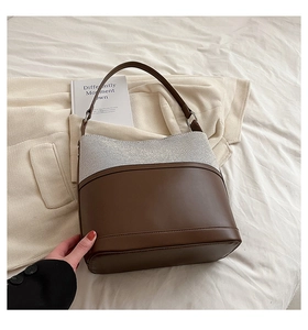 Detail of minimalist bucket bag with contrast stitching and high-quality leather base
