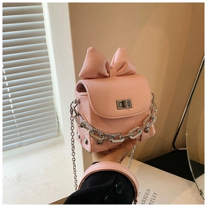 Close-up of mini pink bow bag with rhinestone chain and silver twist lock detail
