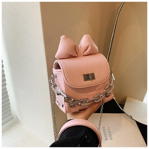 Detailed view of pink mini box bag with large leather bow and silver rotary lock