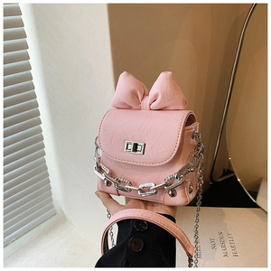 Detail of pink bow handbag with silver chain strap and textured leather finish