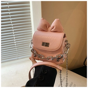 Detailed shot of pink pleated texture bag with large bow and silver chain handle