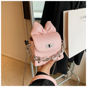Detail of pink bow mini box bag with silver metal lock and textured leather finish