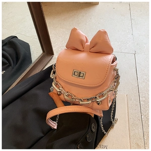Detailed view of pink mini bow bag with metallic twist lock and chunky chain handle