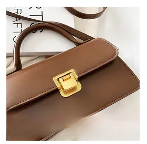 Dettaglio di una borsa in pelle marrone con chiusura in metallo dorato testurizzato